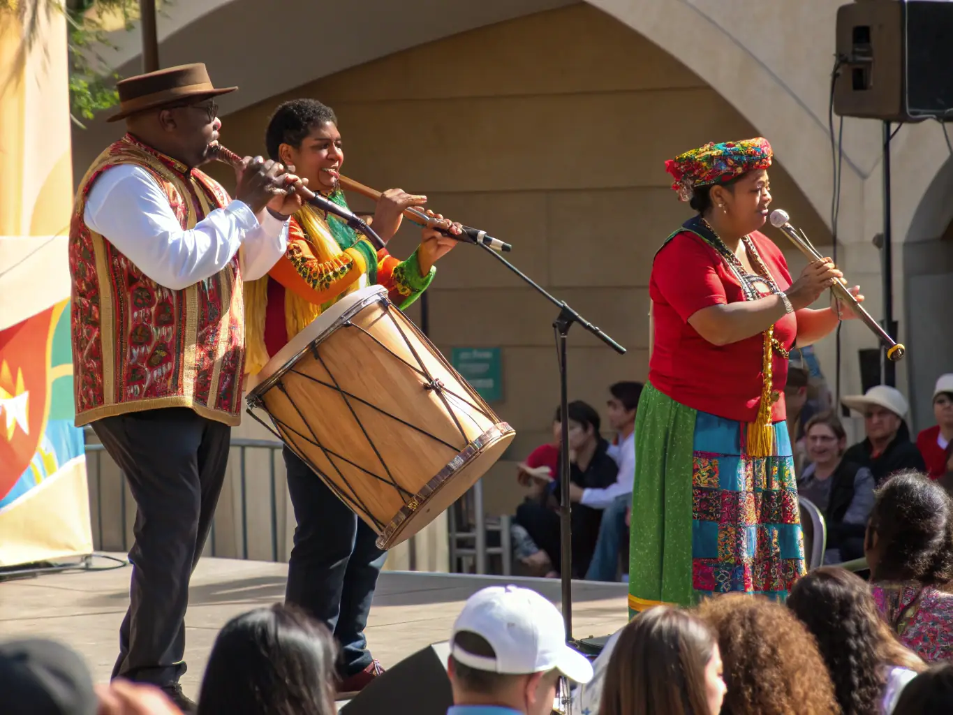 A photograph of a local musical ensemble performing at a festival in the Haut-Bugey region, with rolling hills and picturesque landscapes in the background.